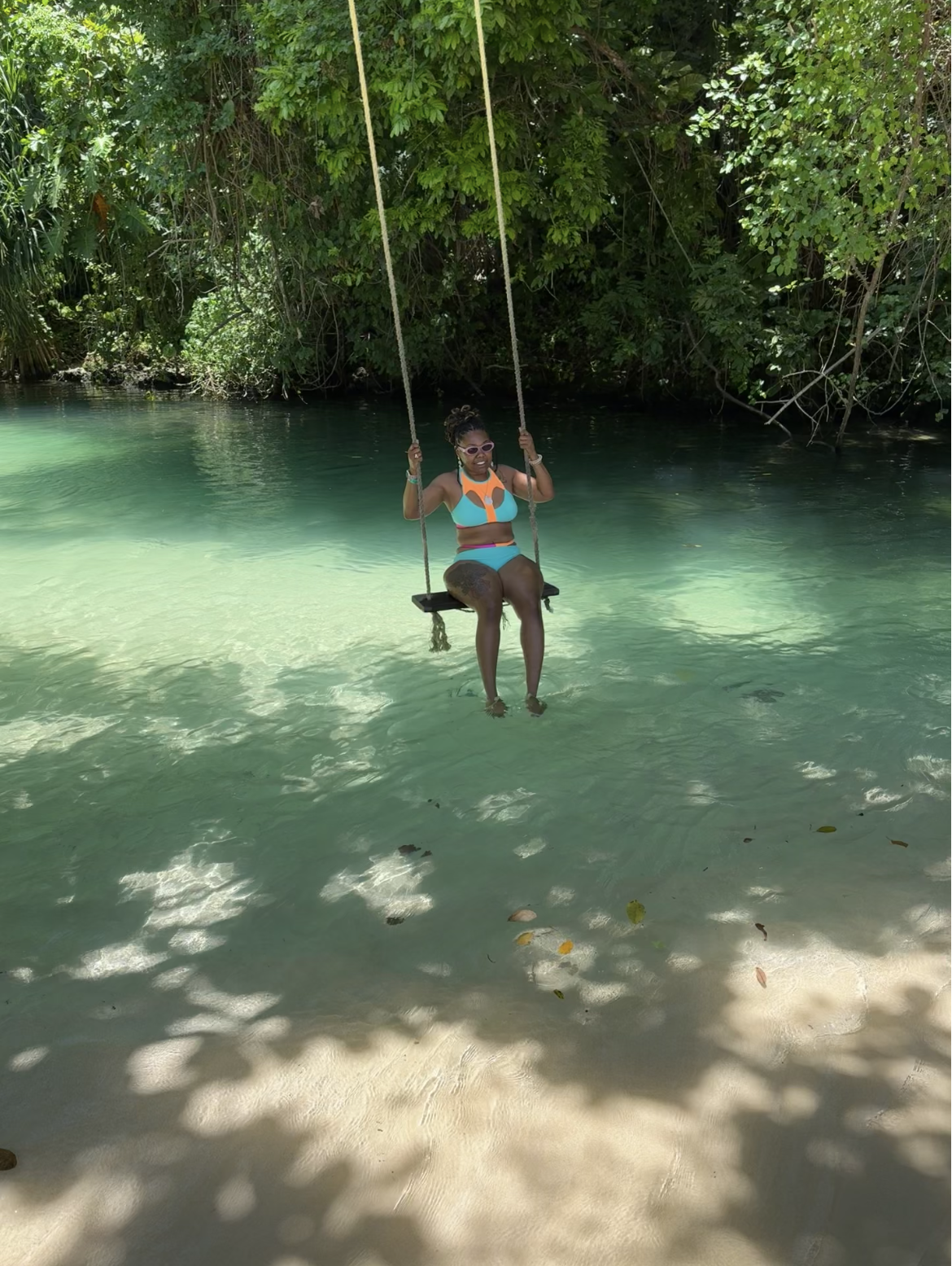 Guest on a rope swing over the turquoise river at Frenchman's Cove, Portland
